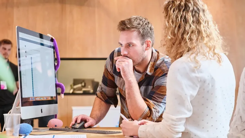Twee collega's van Nedap werken samen aan een bureau