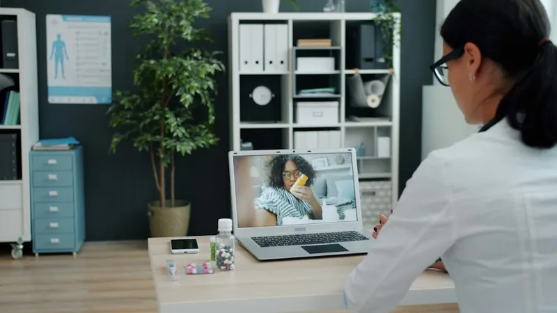 Arts in videoconsult met een patiënt via de laptop